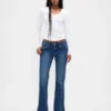 Jeans taille basse, coupe longue et ajustée, avec ourlet fendu