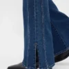 Jeans taille basse, coupe longue et ajustée, avec ourlet fendu