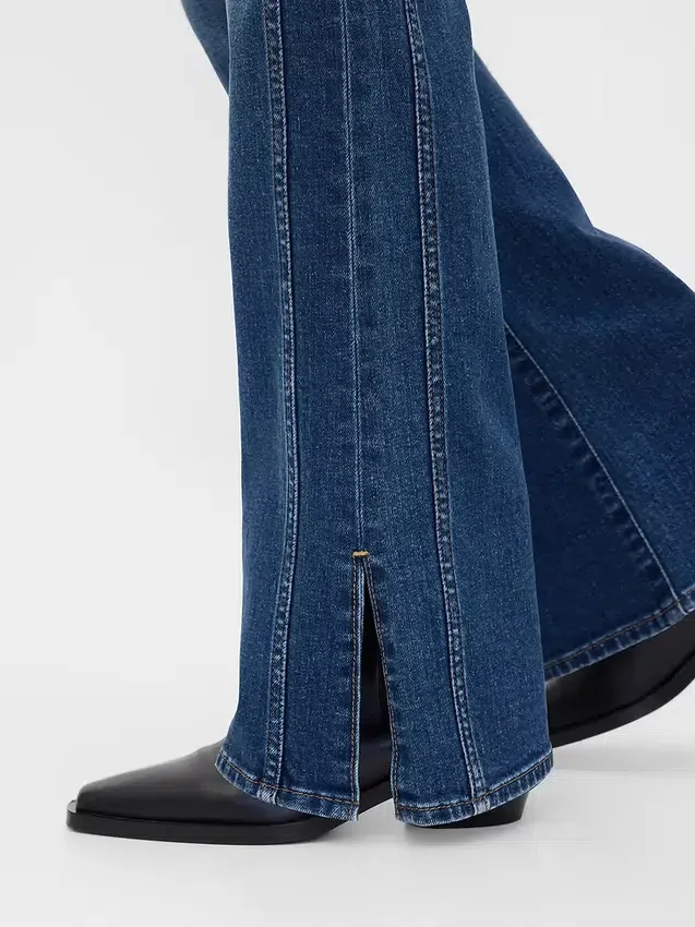 Jeans taille basse, coupe longue et ajustée, avec ourlet fendu
