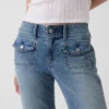 Jeans taille basse, coupe longue et ajustée, avec poches plaquées
