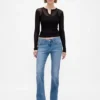 Jeans taille basse, coupe longue et ajustée, ourlet fendu