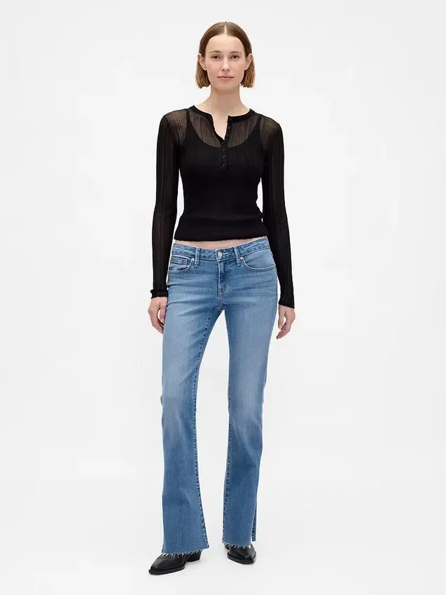 Jeans taille basse, coupe longue et ajustée, ourlet fendu