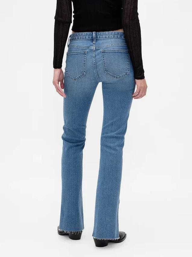 Jeans taille basse, coupe longue et ajustée, ourlet fendu