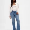 Jeans taille basse, coupe longue et ajustée, ourlet fendu
