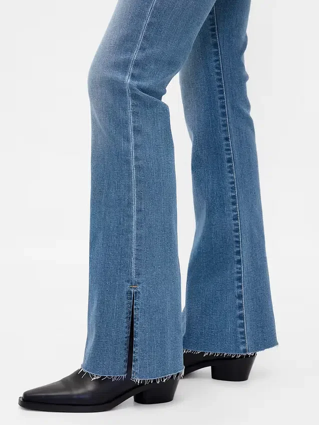 Jeans taille basse, coupe longue et ajustée, ourlet fendu